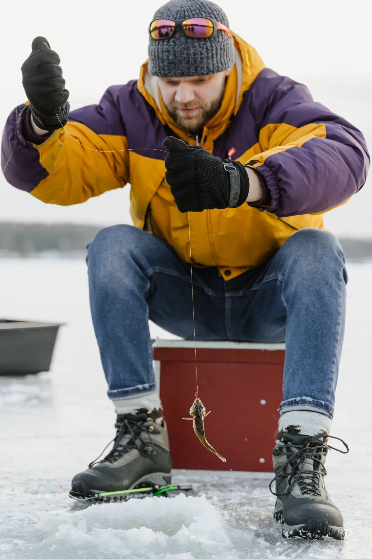 Person ice fishing in winter equipment